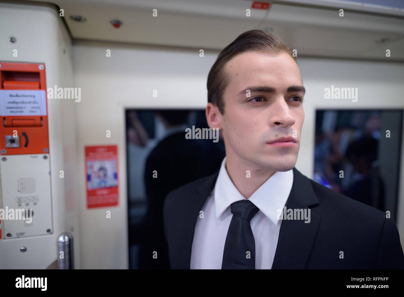 Young businessman wearing suit and thinking inside train Stock Photo