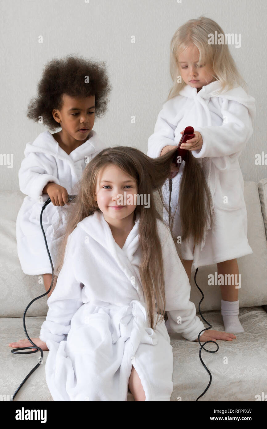 Hair care in children. Baby hairstyles. Girls 5-7 years old make each other  hair on their heads Stock Photo - Alamy