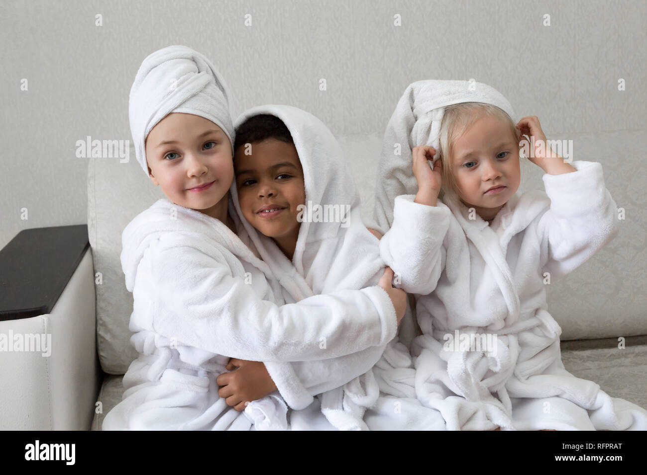 Children having fun after taking a shower. Girls in bathrobes and towels on the head after