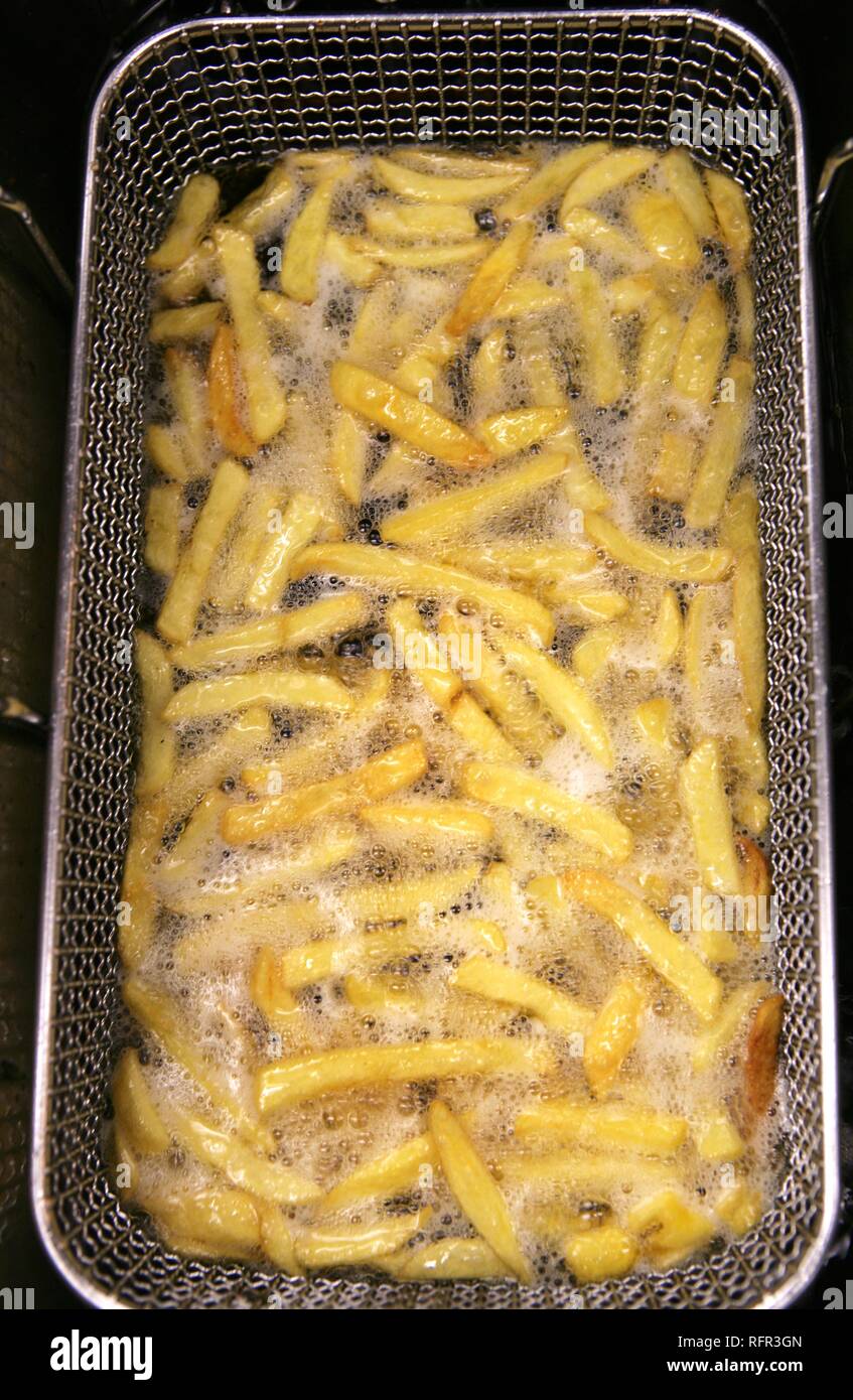 Chips frying in a deep fryer Stock Photo Alamy