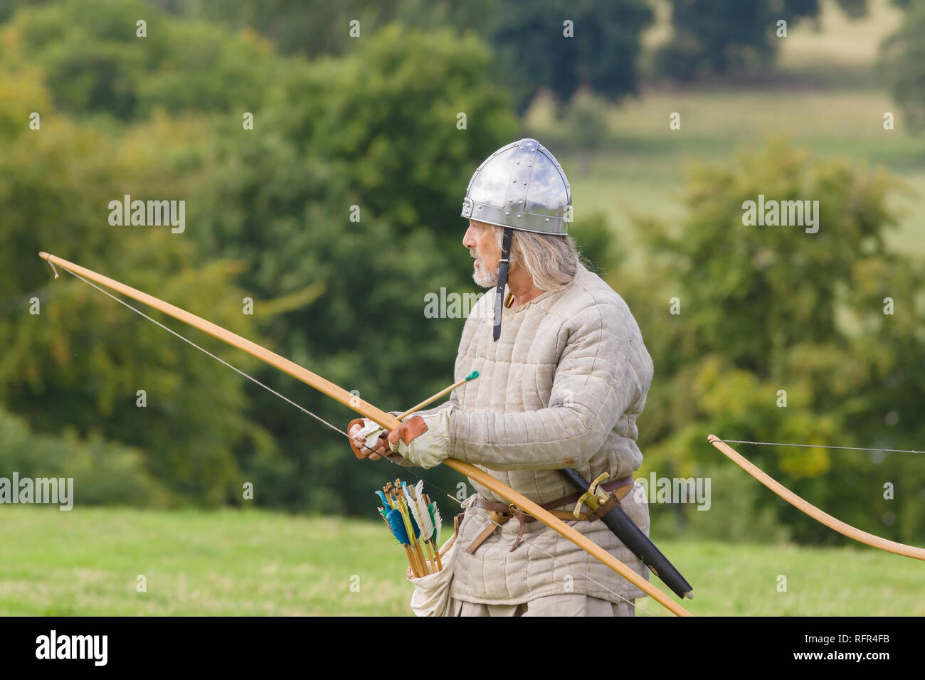 Medieval re-enactor dressed as an archer of the 12th century equiped with a long bow re-enacting combat of the period Stock Photo