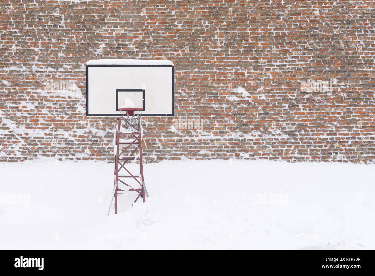 Basketball hoop in the winter, covered with snow. Stock Photo