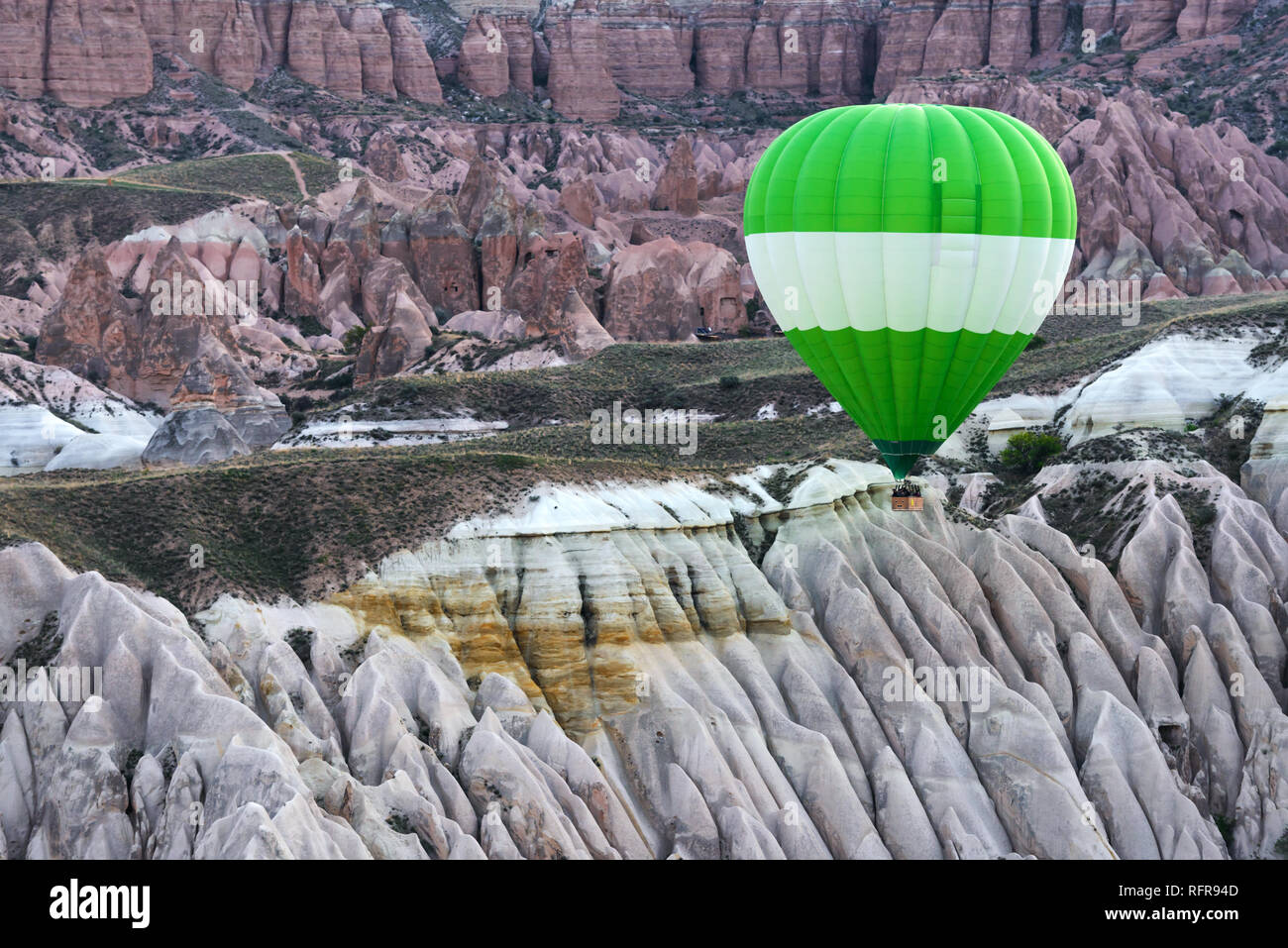 Green ballon in the sunrise mountains. Cappadocia, Turkey. Landscape photography Stock Photo