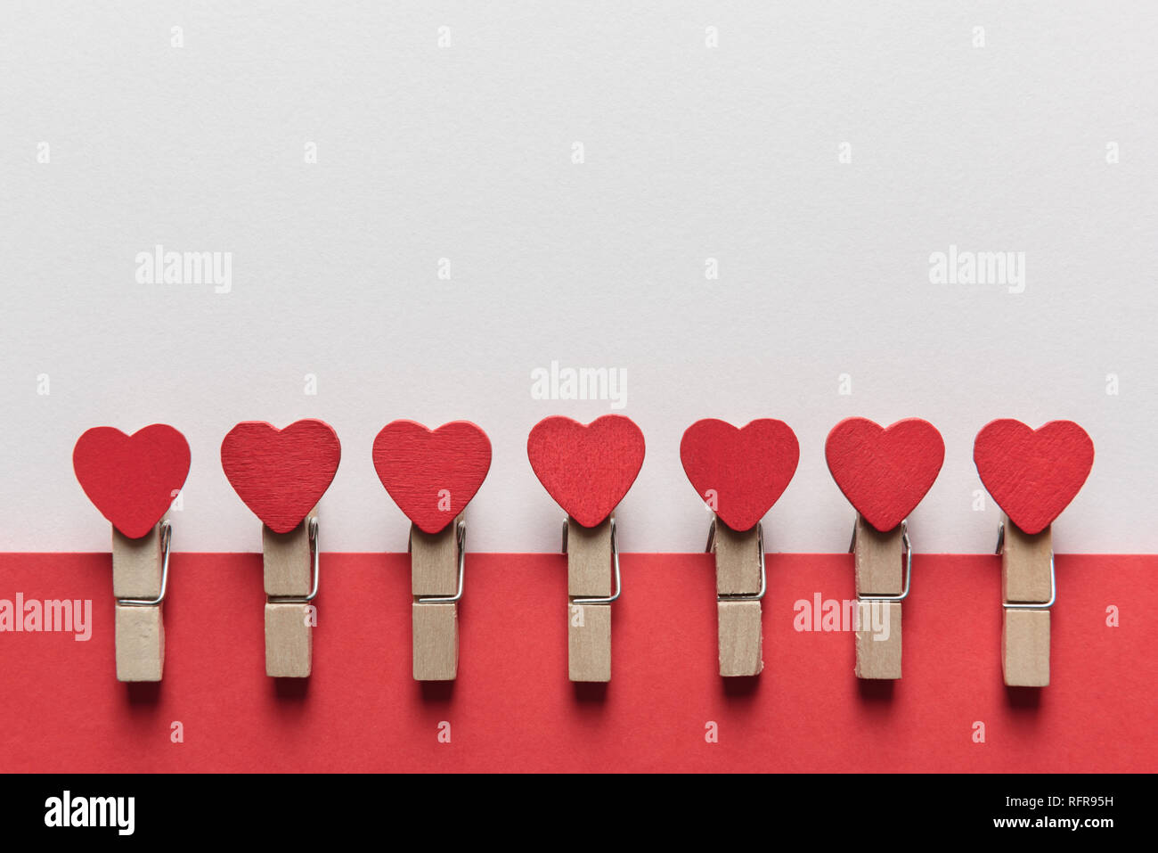 Wooden clothes pin with red textile hearts. Valentines day background, creative texture and love concept Stock Photo