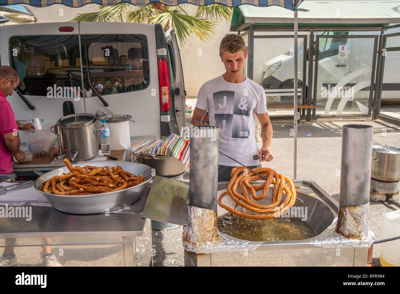 father and son preparing churros in a Spanish market Stock Photo