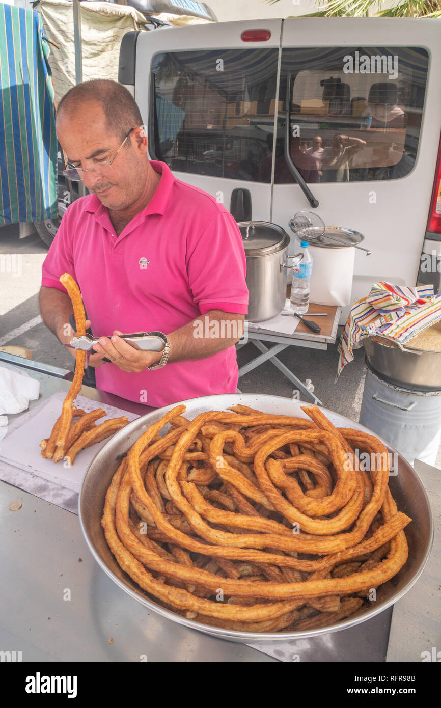 father and son preparing churros in a Spanish market Stock Photo