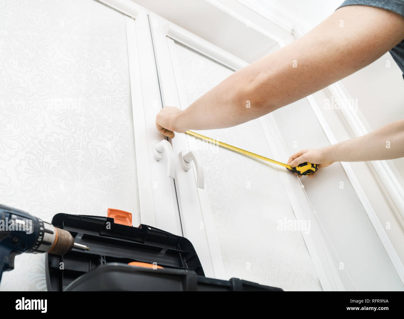 Man installing cassette roller blinds on windows Stock Photo
