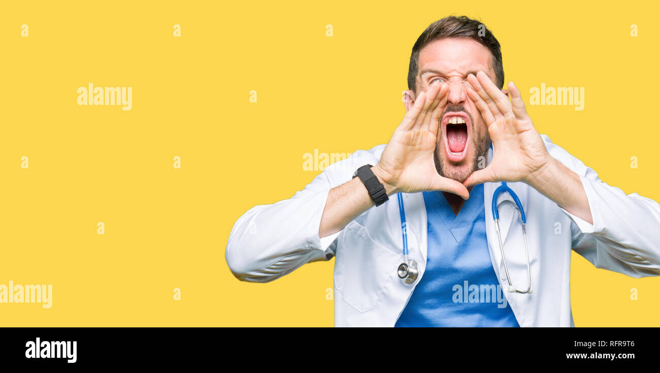 Handsome doctor man wearing medical uniform over isolated background ...