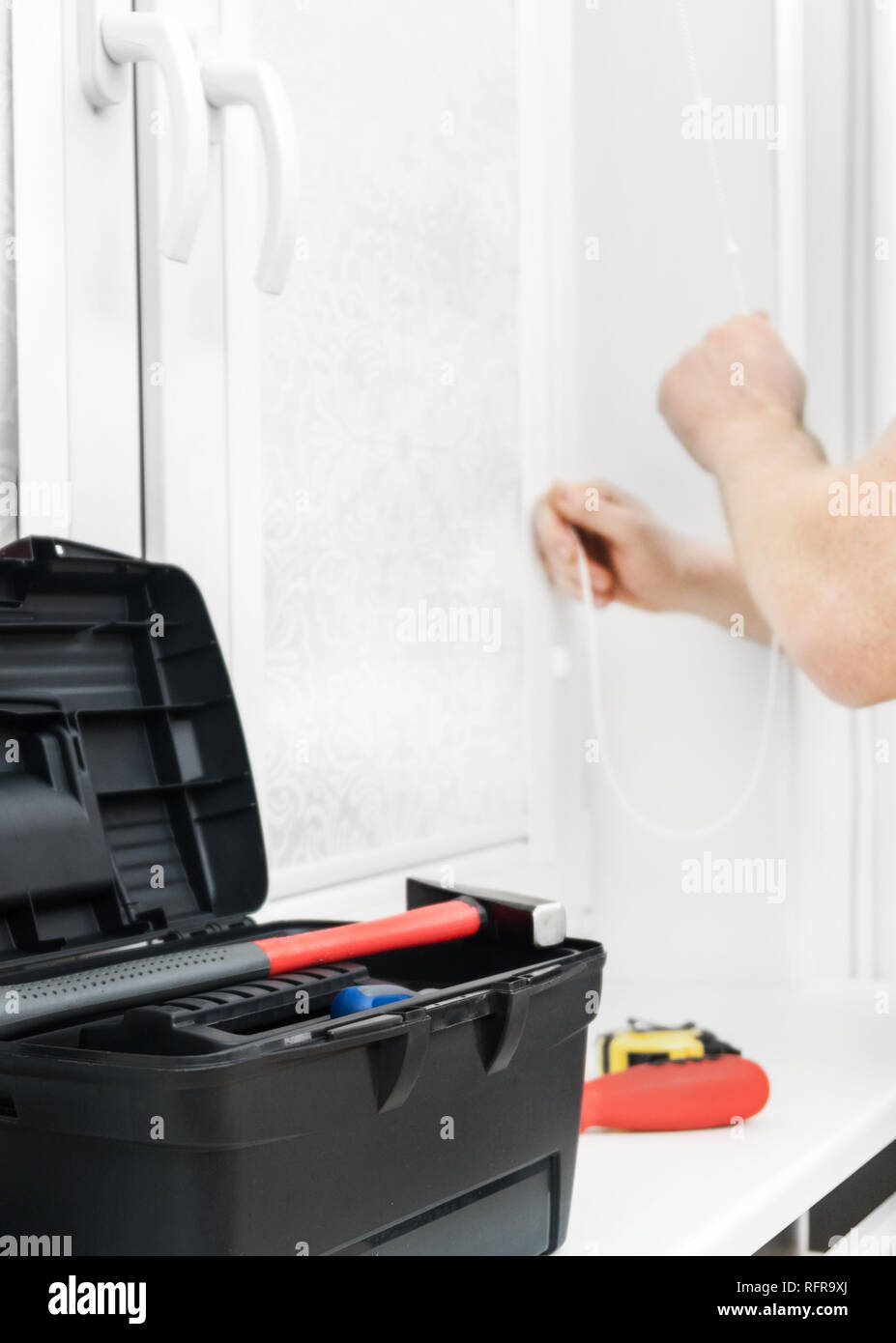 Man testing cassette roller blinds on windows. Stock Photo