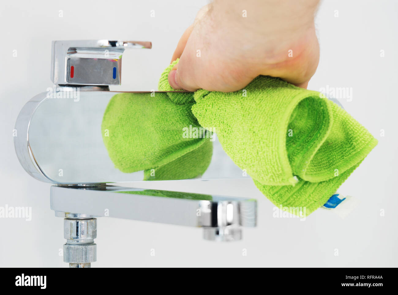 House cleaning. Man cleaning tap in bathroom Stock Photo Alamy