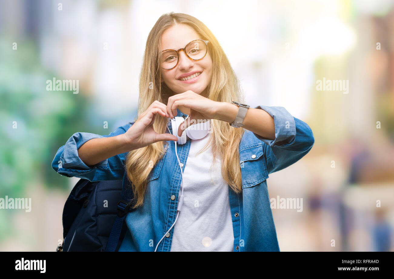 Young beautiful blonde student woman wearing headphones and glasses ...