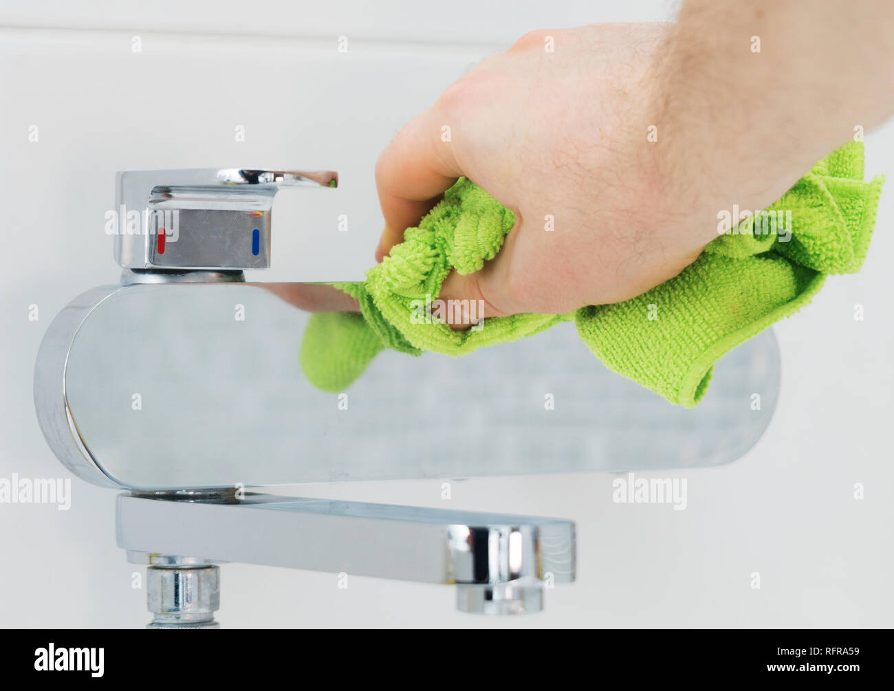 House cleaning. Man cleaning tap in bathroom Stock Photo Alamy