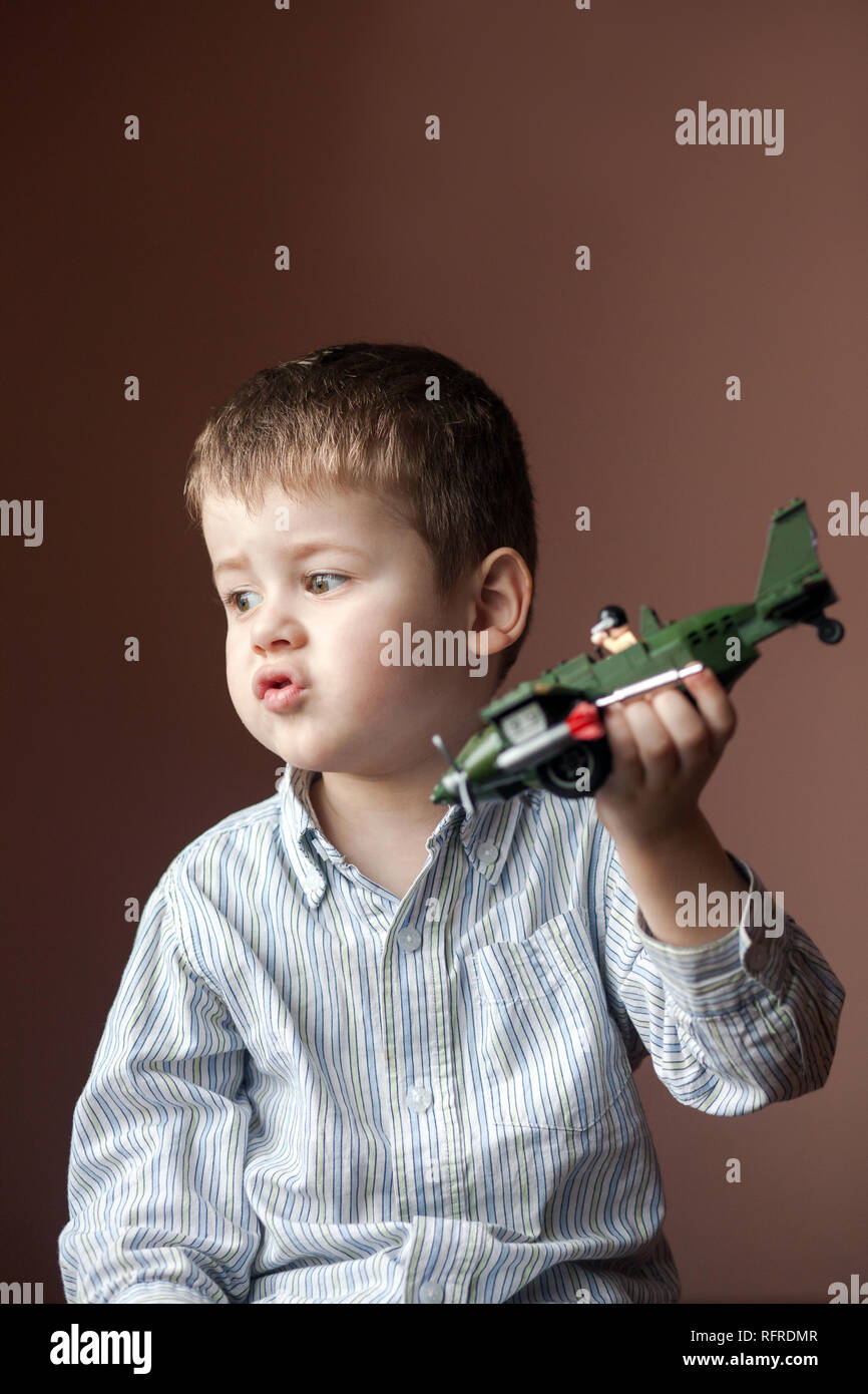 Cute Little Boy Playing With A Toy Airplane. Military Aircraft Lego Stock  Photo - Alamy