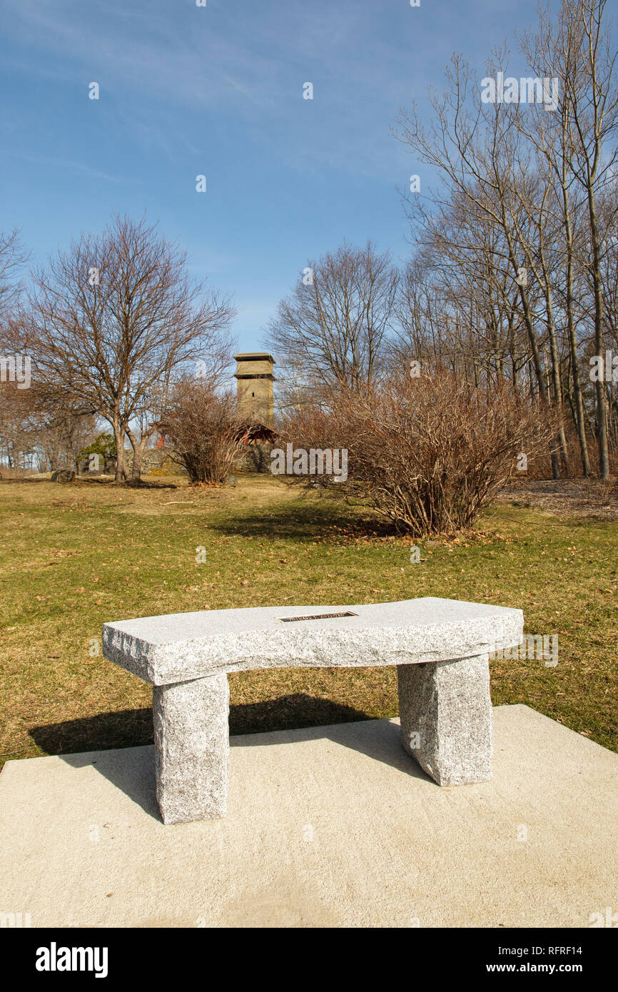 Granite bench along a walking path at Fort Foster Park in Kittery, Maine USA. This old fort is located on the coast of Maine. Stock Photo
