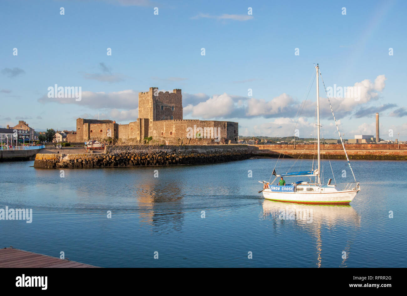 Carrickfergus, Northern Ireland, UK - August 24, 2018: Medieval Norman Castle, yacht, sailor, harbor, breakwater and power plant in Carrickfergus Stock Photo