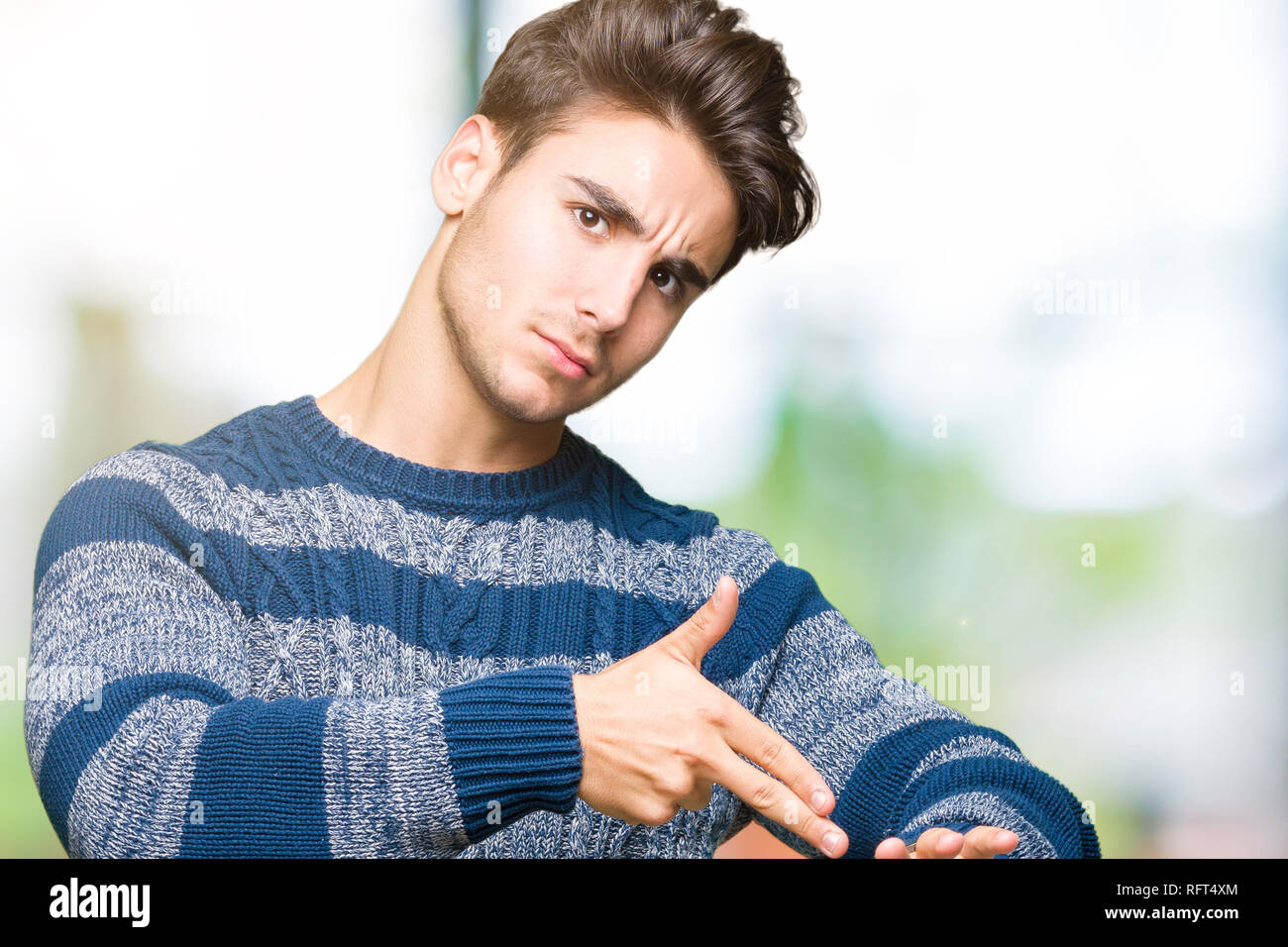 Young handsome man over isolated background In hurry pointing to watch time, impatience, upset and angry for deadline delay Stock Photo