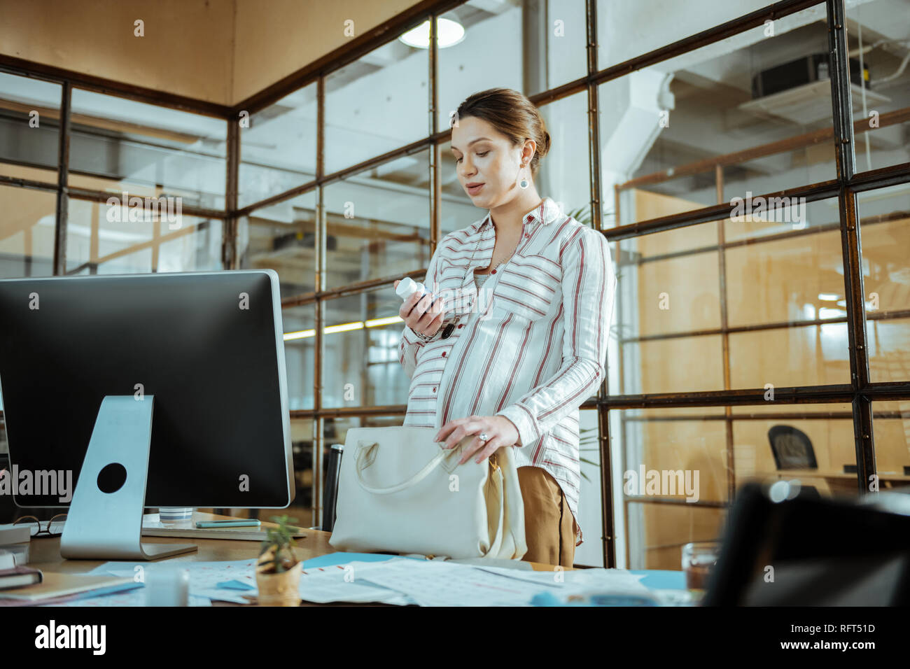 Pregnant businesswoman taking her vitamins after work Stock Photo Alamy
