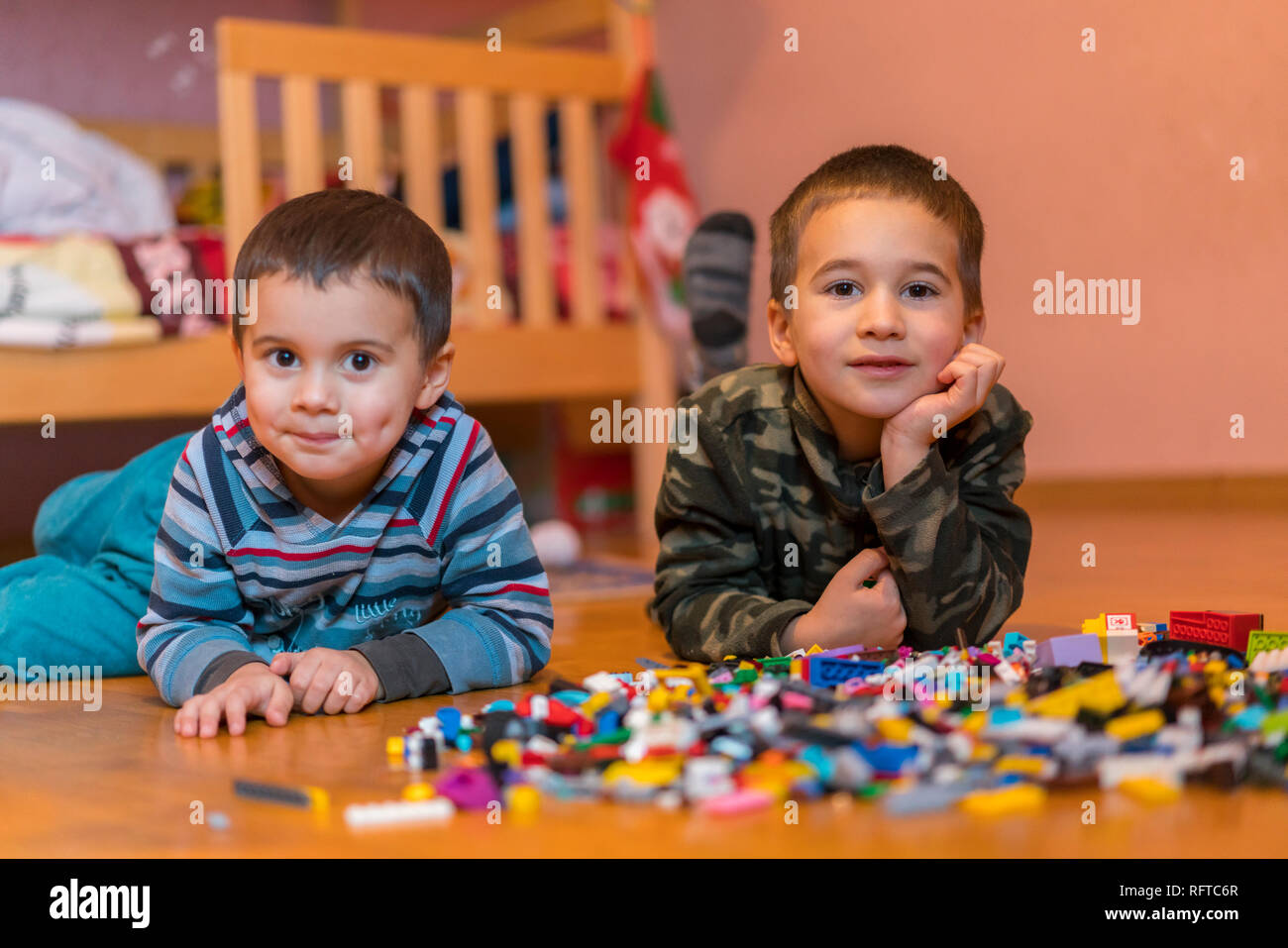Two children playing with lots of colorful plastic blocks constructor ...