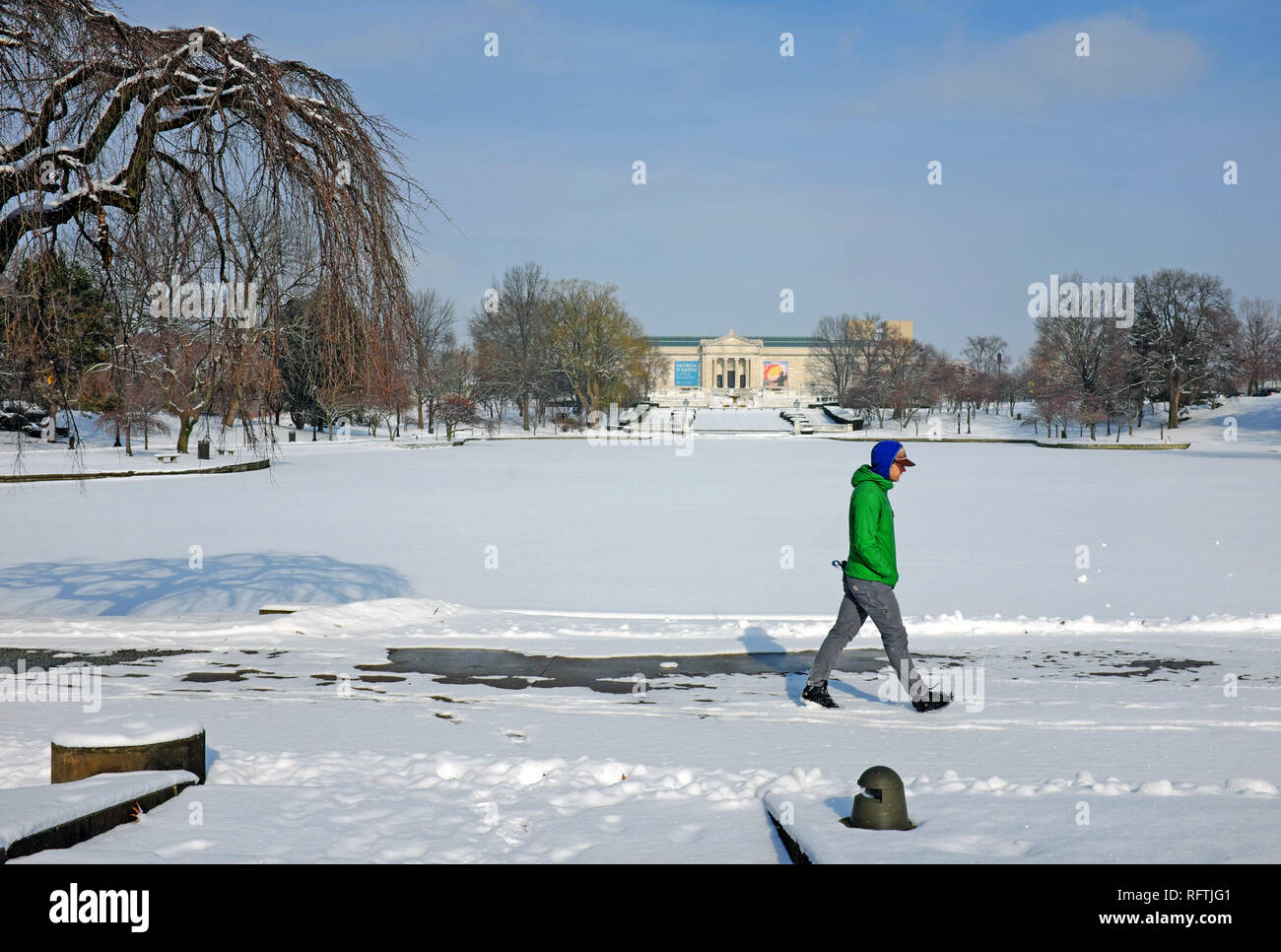 Cleveland, Ohio, USA.  26th Jan, 2019.  A man walks around the frozen Wade Park Pond in Cleveland, Ohio, USA as arctic temperatures engulf the city.  The Cleveland Museum of Art is in the far background.  Credit: Mark Kanning. Credit: Mark Kanning/Alamy Live News Stock Photo