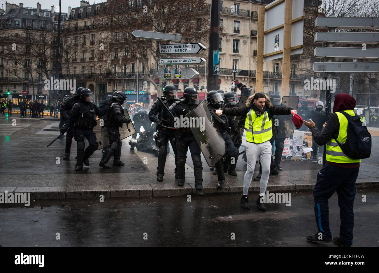 A riot police lay down injured while a yellow vest protestor is being attacked by a police officer during a demonstration against macron policies. Yellow vest protestors gathered and march on the streets of Paris another Saturday on what they call the Act XI against the French president Emmanuel Macron policies. Stock Photo