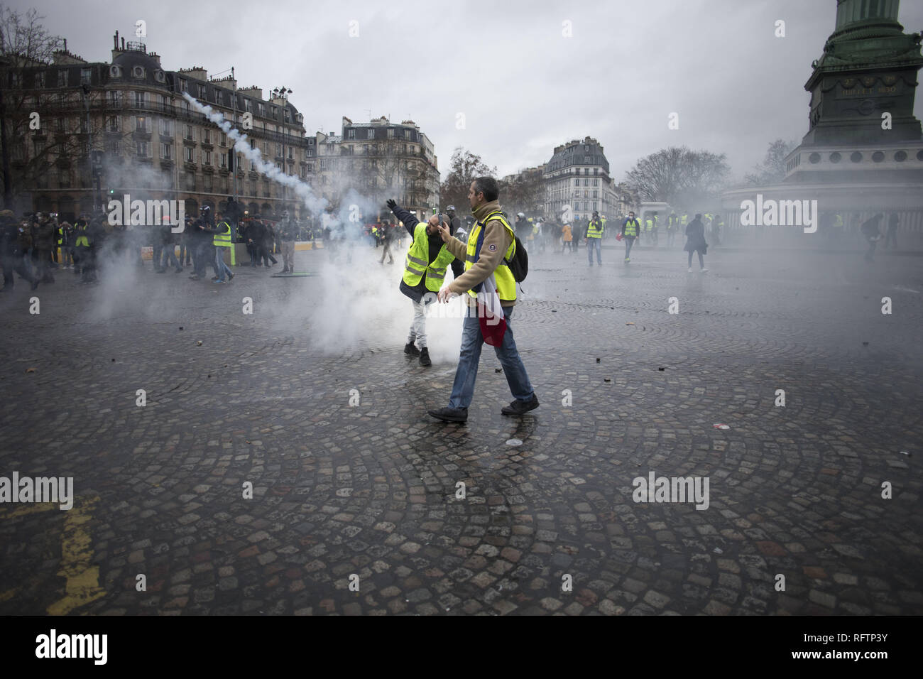 Paris, Ile de France, France. 26th Jan, 2019. A yellow vest protestor throws back the tear gas cannister to the police (not pictured) during a demonstration against macron policies. Yellow vest protestors gathered and march on the streets of Paris another Saturday on what they call the Act XI against the French president Emmanuel Macron policies. Credit: Bruno Thevenin/SOPA Images/ZUMA Wire/Alamy Live News Stock Photo