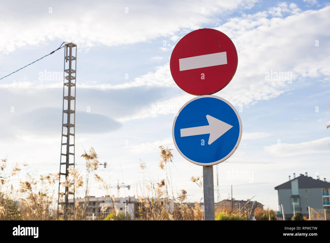 Blue road sign with white arrow to the right and no entry sign Stock