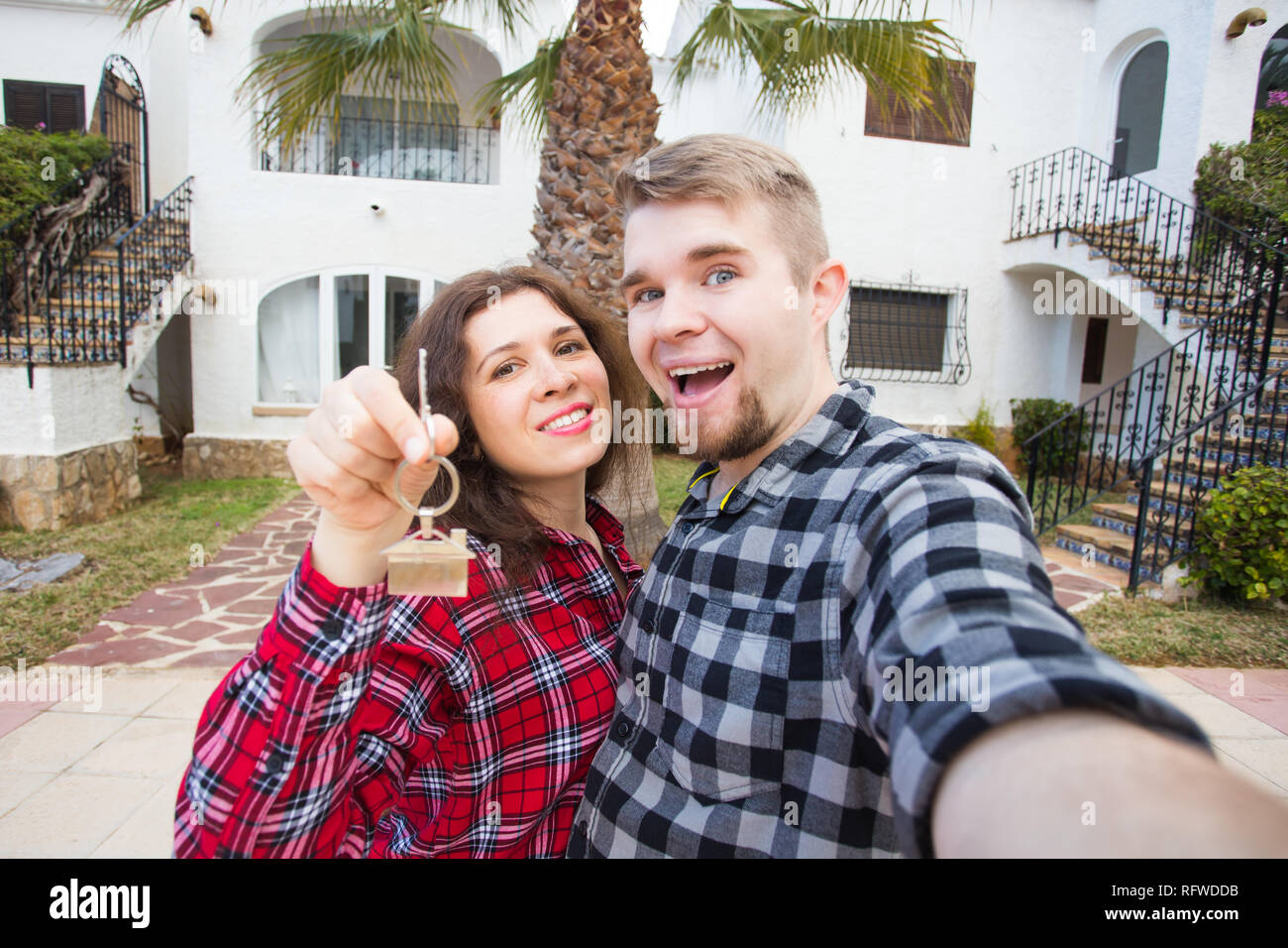 Real estate and property concept - Happy couple holding keys to new ...