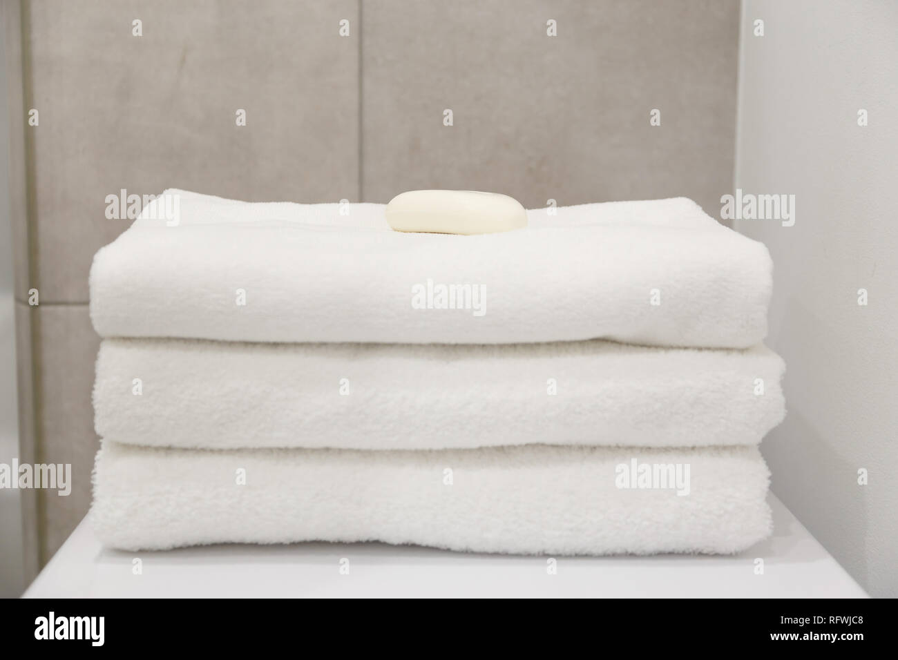 Stack of white clean towels on table in bathroom Stock Photo
