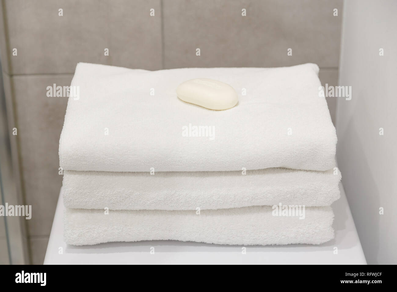 Stack of white clean towels on table in bathroom Stock Photo