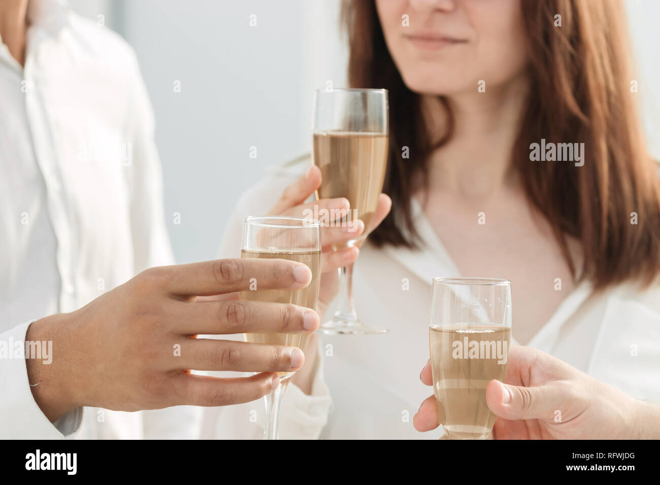 close up. business team raising glasses of wine in the new office. Stock Photo
