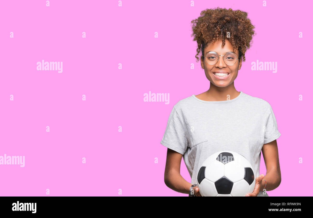 Young african american woman holding soccer football ball over isolated ...