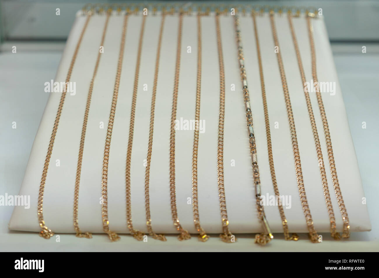 Gold chains on the showcase. gold jewelry. Gold necklace in red background  on showcase jewelry - luxury brilliant jewelry platinum chain gold. toned  Stock Photo - Alamy
