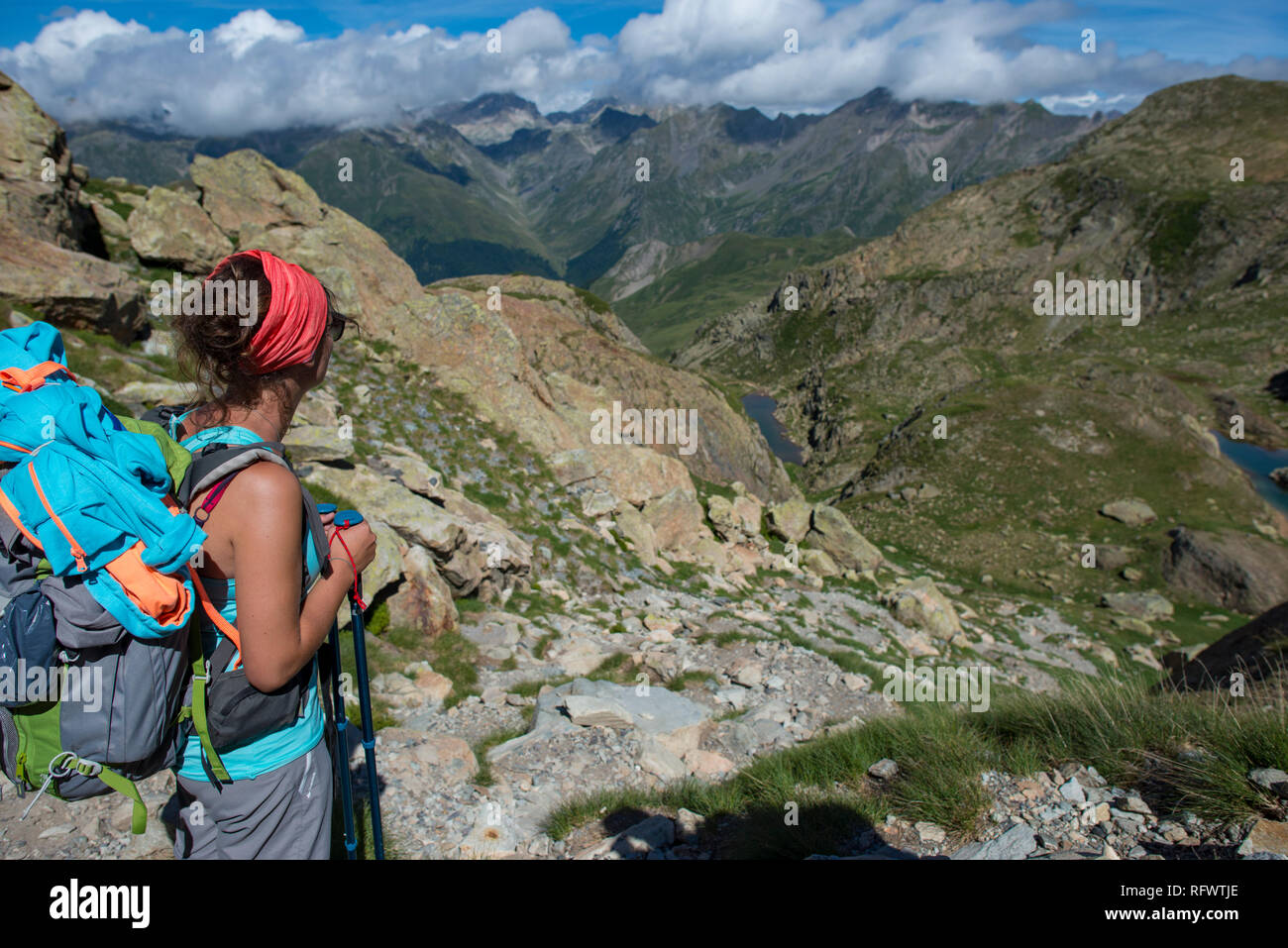 A hiker looks out at the Pyrenees mountains from the top of Col Peyreget while hiking the GR10 trekking trail, Pyrenees Atlantiques, France, Europe Stock Photo