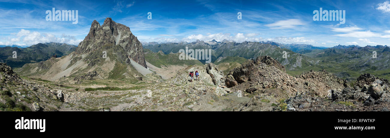 Walkers descend from the top of Pic Peyreget while hiking the GR10 trekking trail, Pyrenees Atlantiques, France, Europe Stock Photo