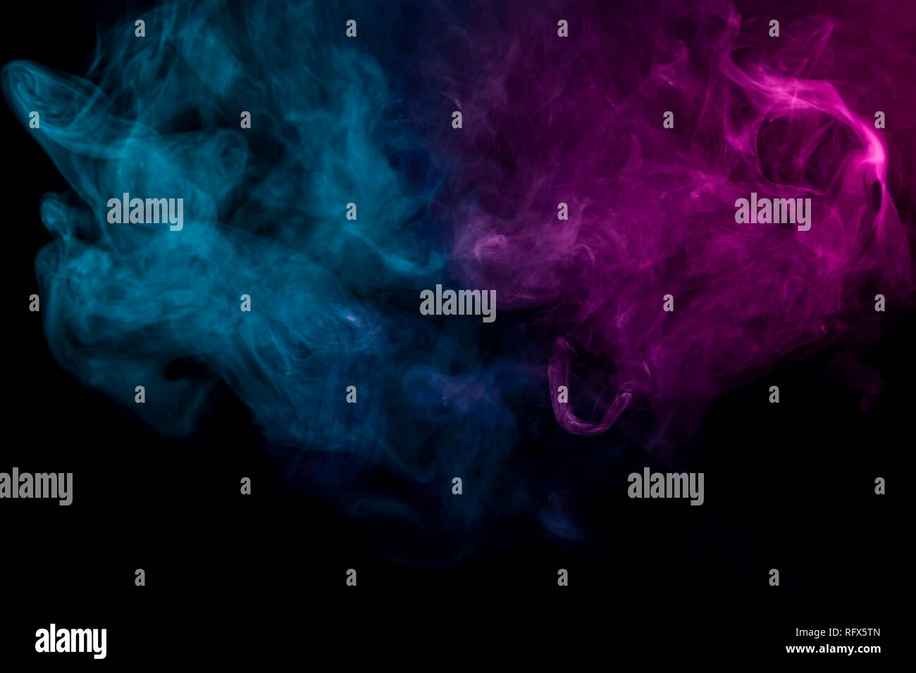 Dense multicolored smoke of pink and blue colors on a black isolated ...