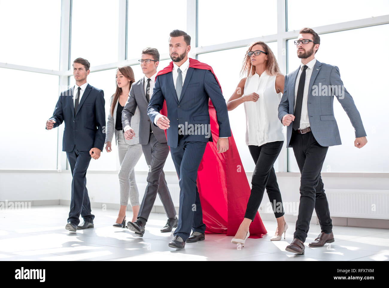 businessman in Superman cloak and business team standing in office ...