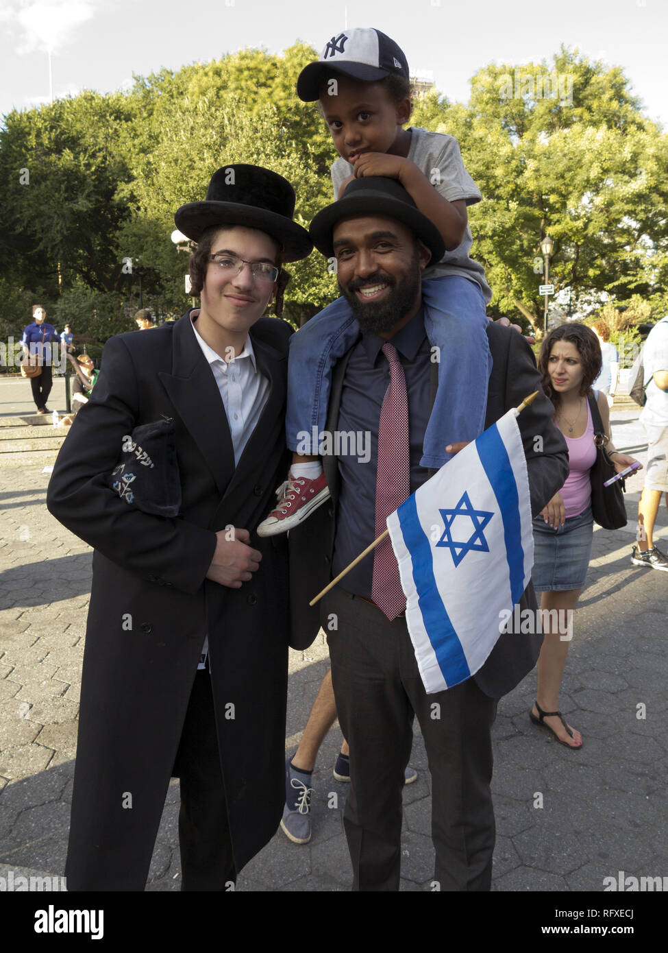 Ethiopian Jew from Israel and son pose for photo with Hasidic teen at Rally in Support of Israel and Persecuted Religious Minorities under Islam at Un Stock Photo