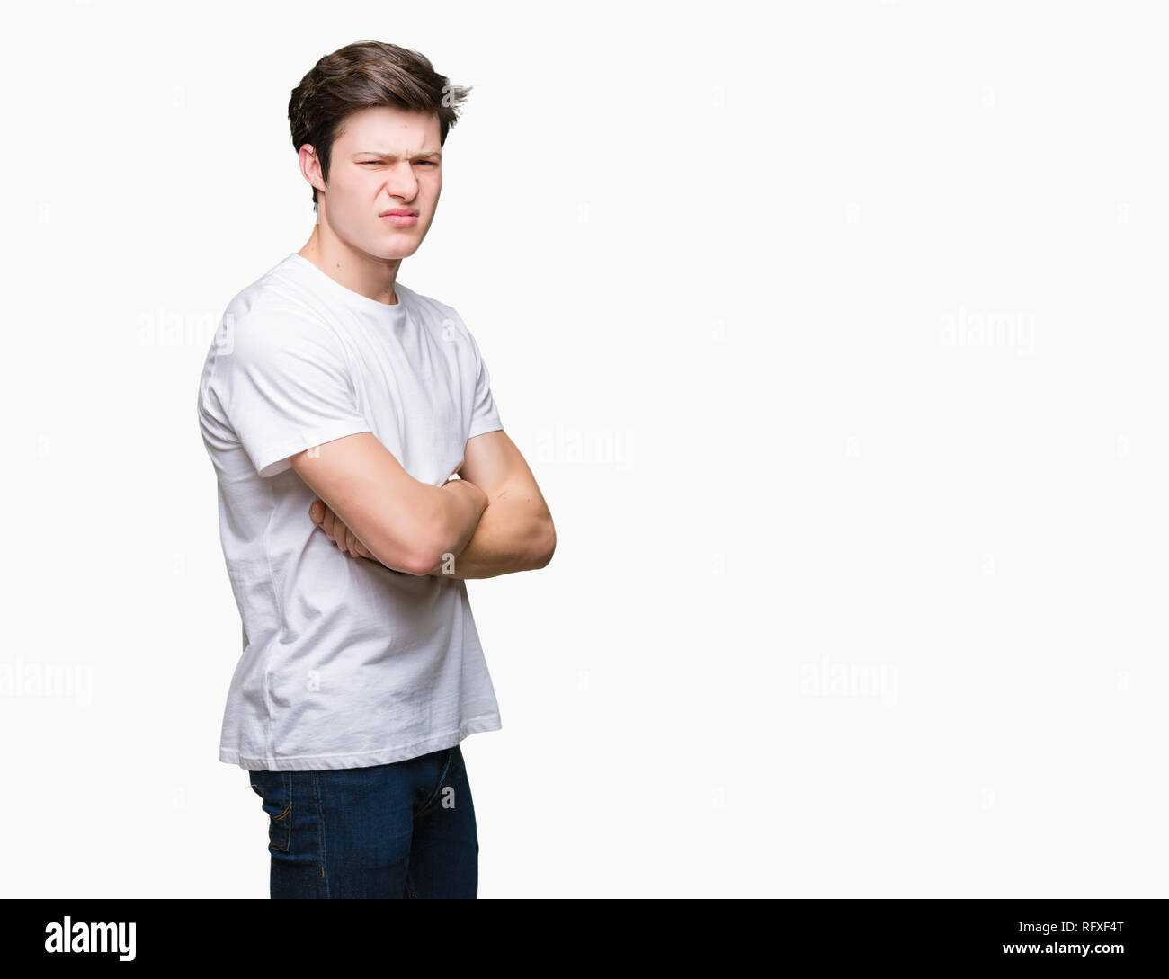 Young handsome man wearing casual white t-shirt over isolated background skeptic and nervous, disapproving expression on face with crossed arms. Negat Stock Photo