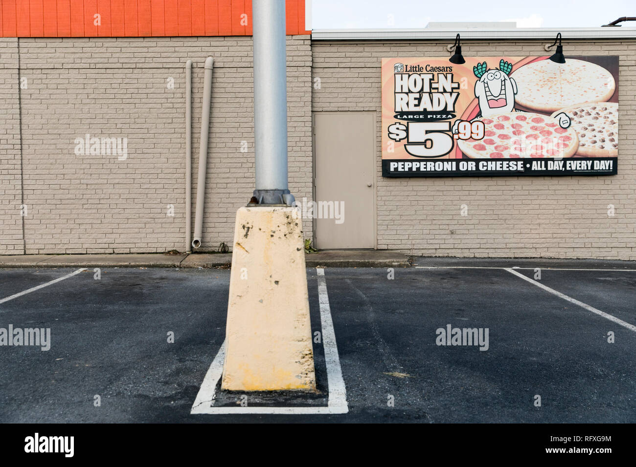 A logo sign outside of a Little Caesars restaurant location in