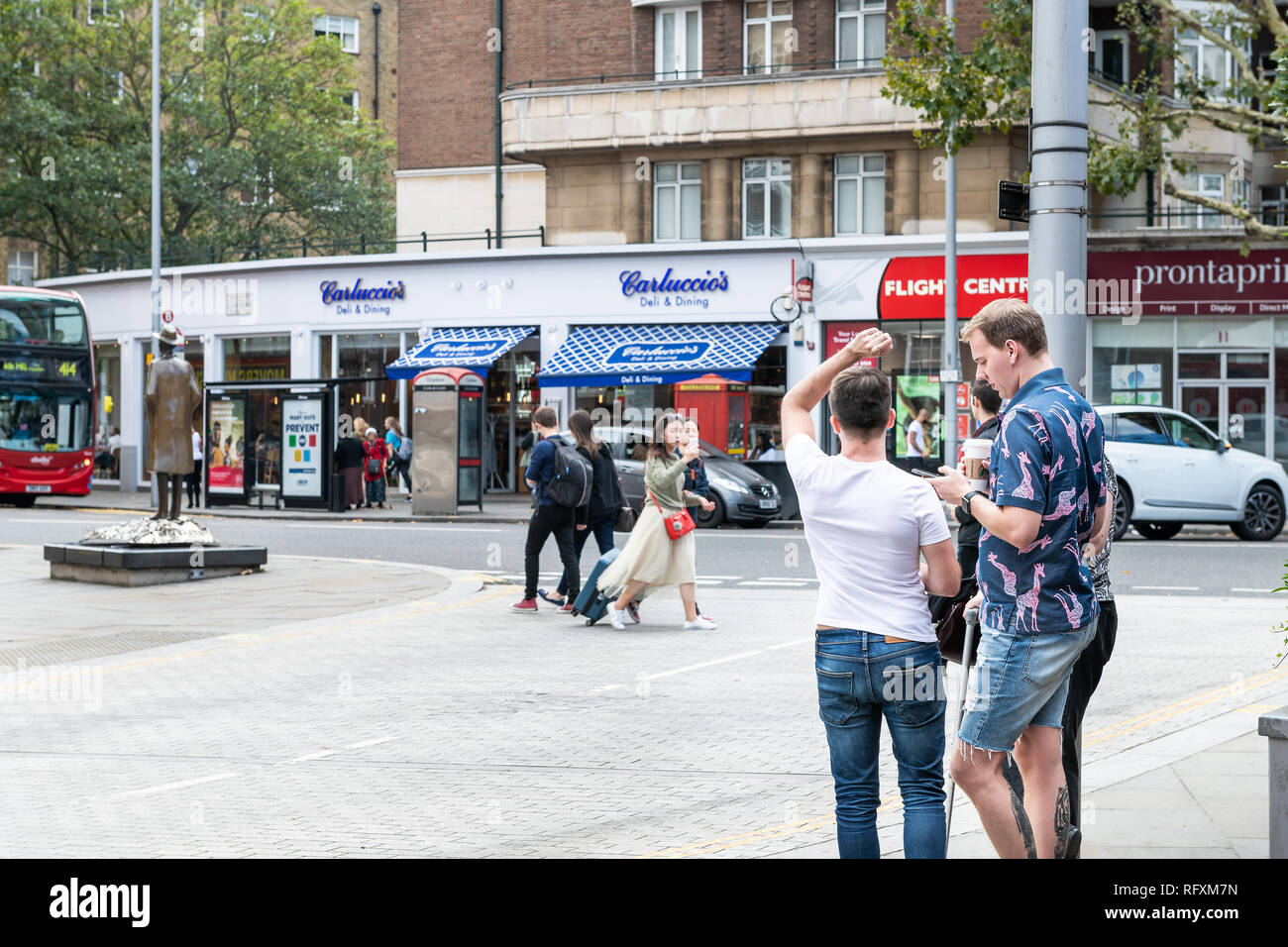 London, UK - September 16, 2018: Neighborhood district of South Kensington street and shopping stores people walking on sidewalk pavement crossing roa Stock Photo