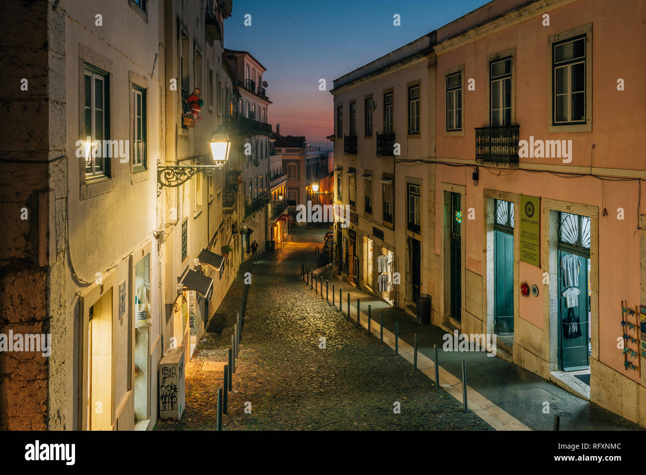 A narrow cobblestone street at night, in Alfama, Lisbon, Portugal Stock ...