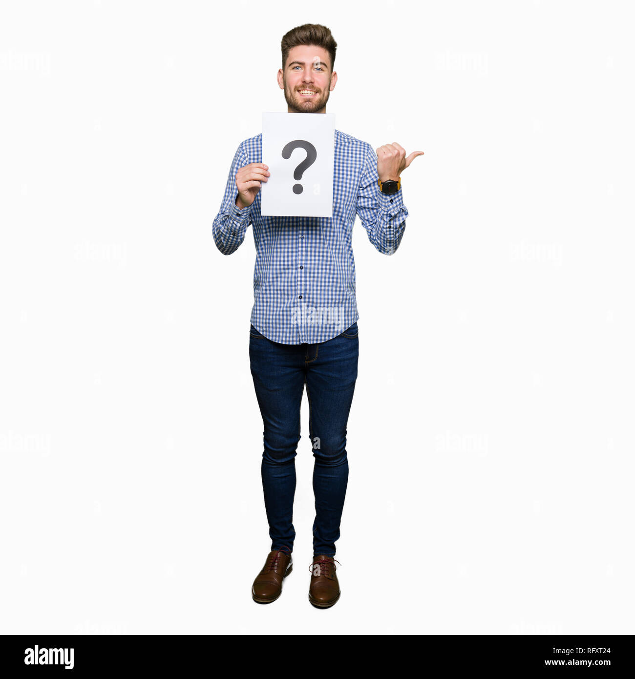 Young handsome man holding paper with question mark pointing and ...