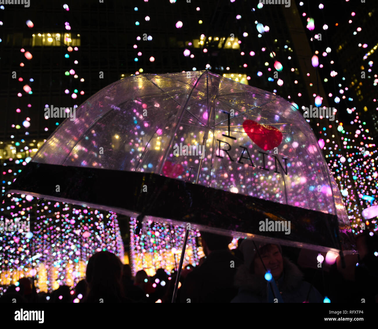 Clear umbrella in the rain and lights at london canary wharf  winter lights festival 2019 Stock Photo