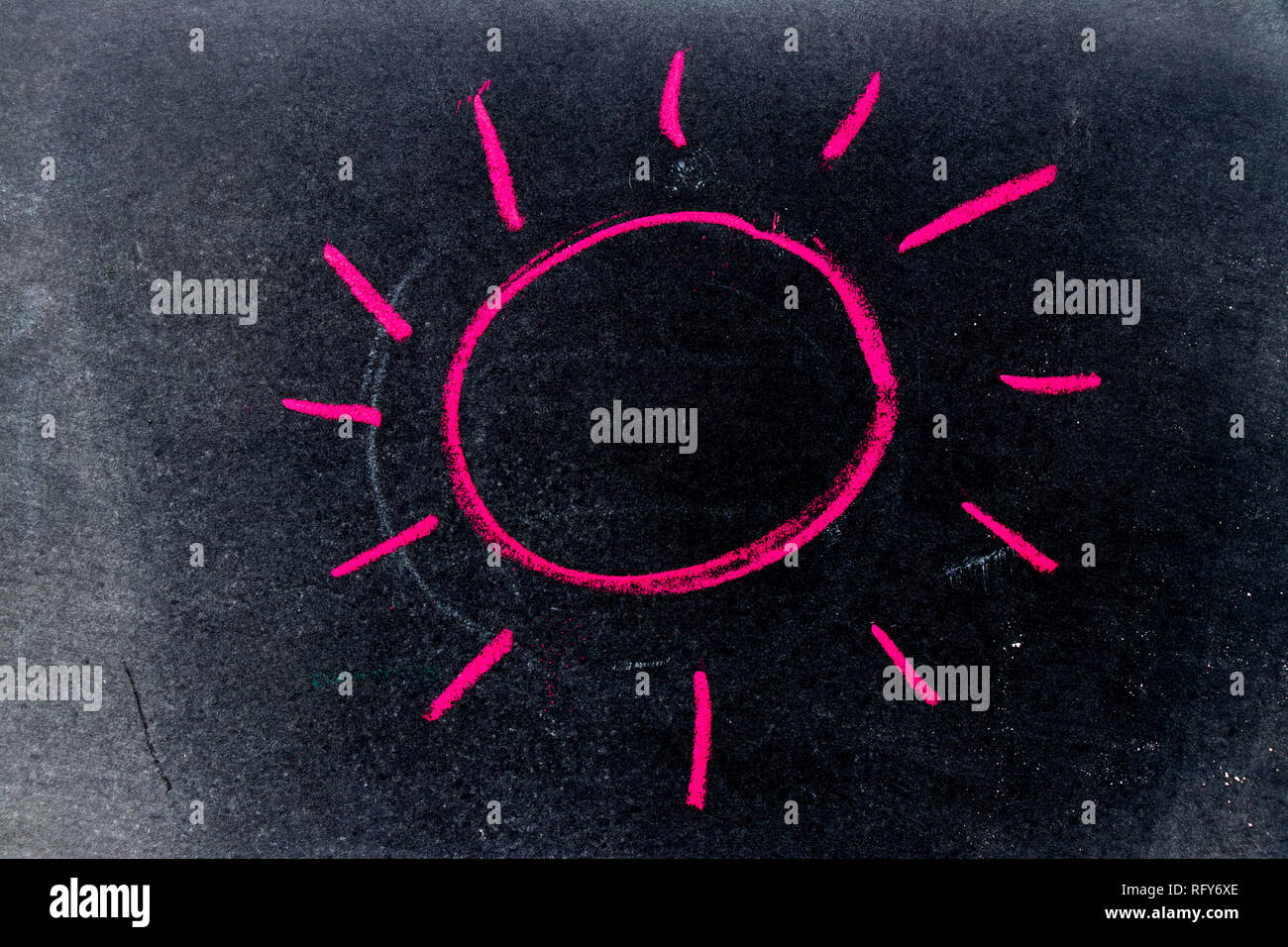 Red chalk drawing as sun with ray on black board background Stock Photo Alamy