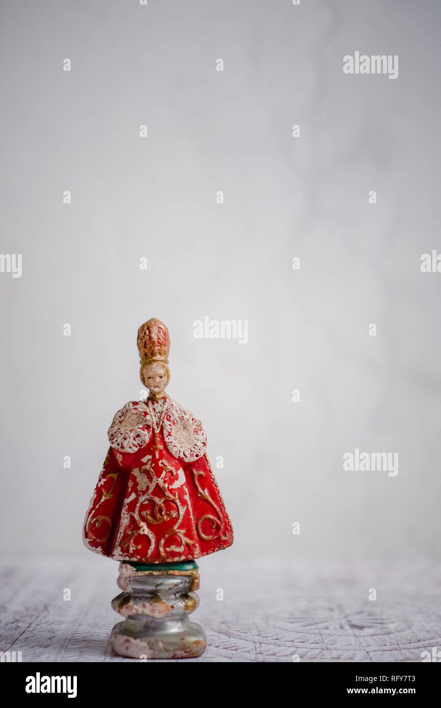 Antique statue of the Infant Jesus of Prague, against a light background. The original statue is a 16th-century wax-coated wooden statue of the Christ Stock Photo