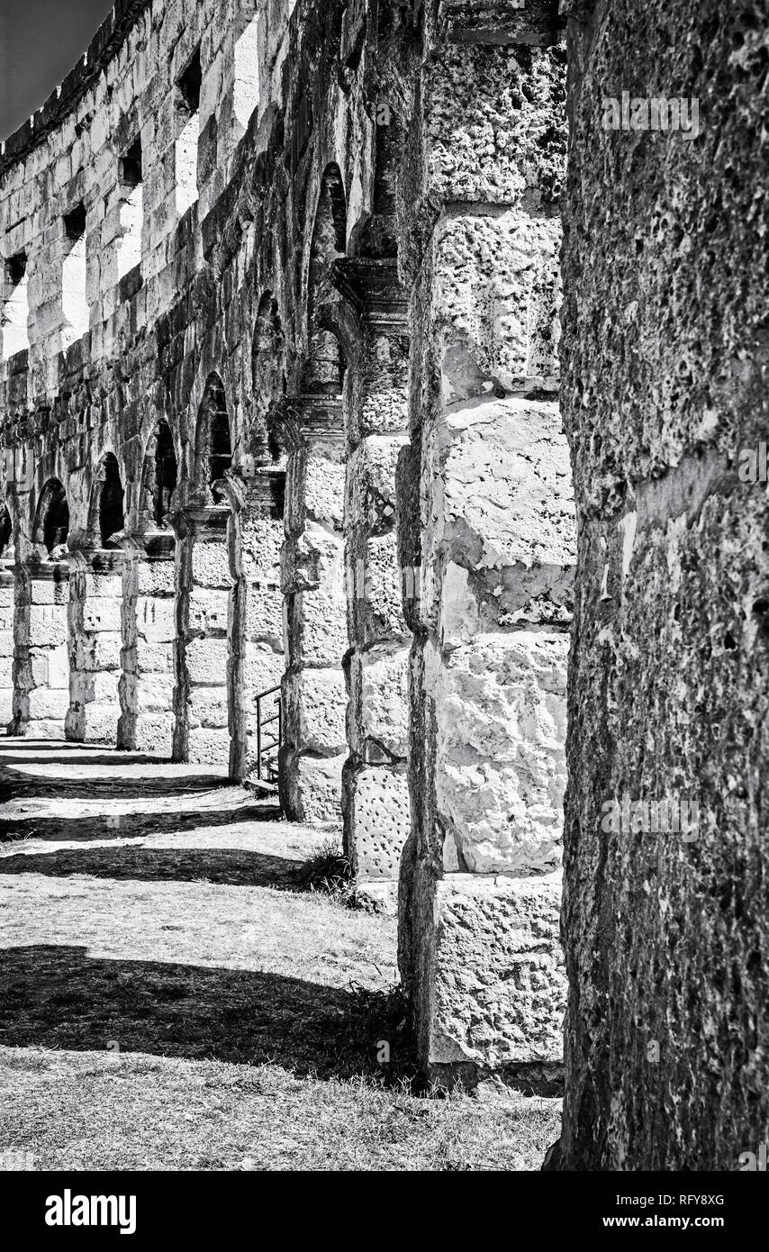 Detail photo of Pula Arena, Istria, Croatia. Travel destination. Ancient architecture. Vertical composition. Black and white photo. Stock Photo