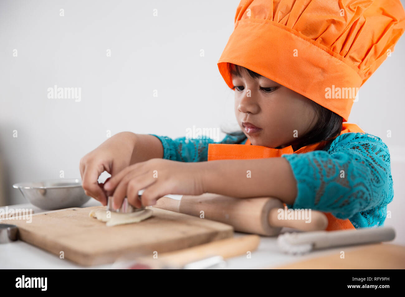 girl with apron making cookies Stock Photo Alamy
