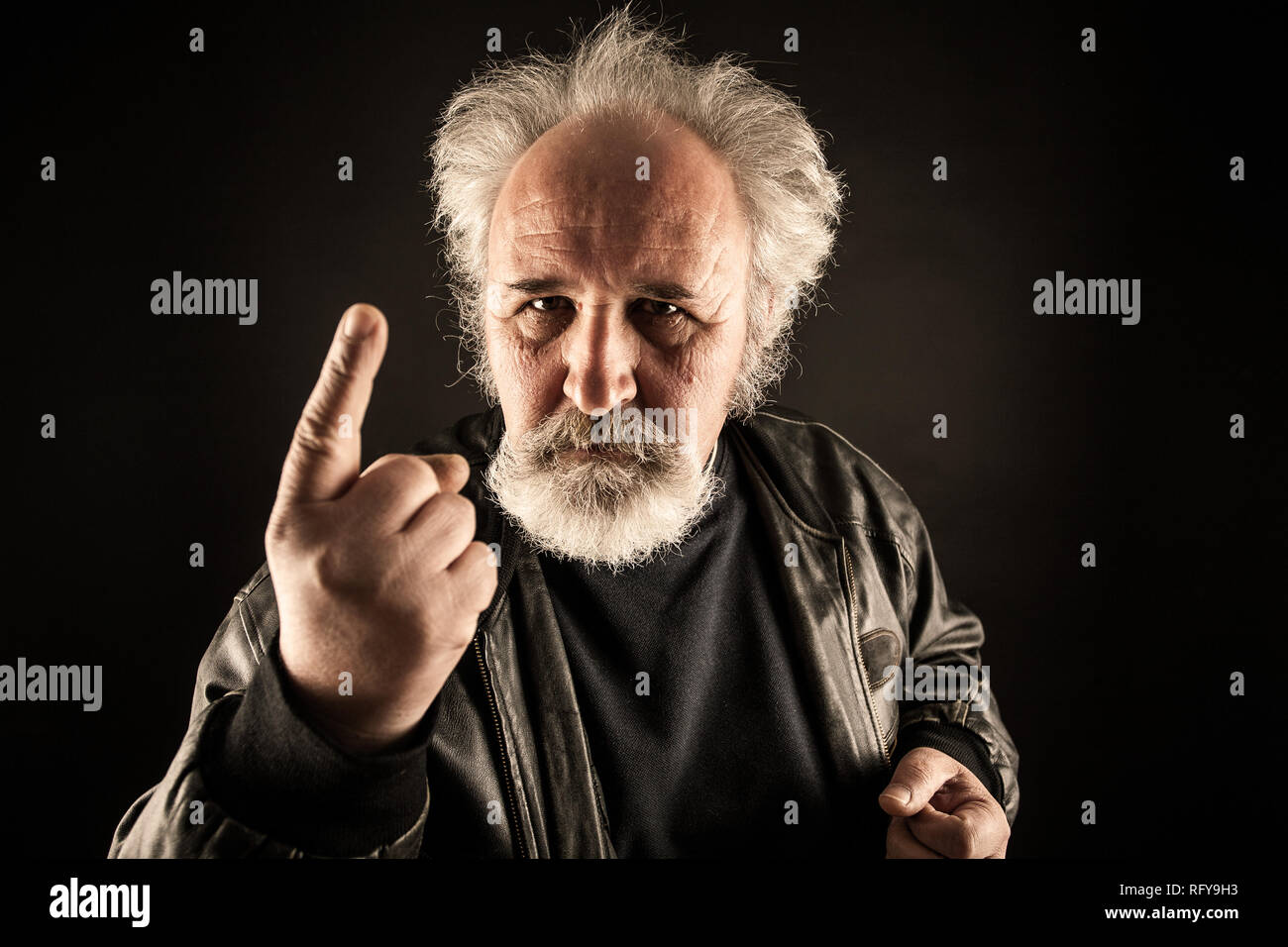 Grumpy man against black background Stock Photo