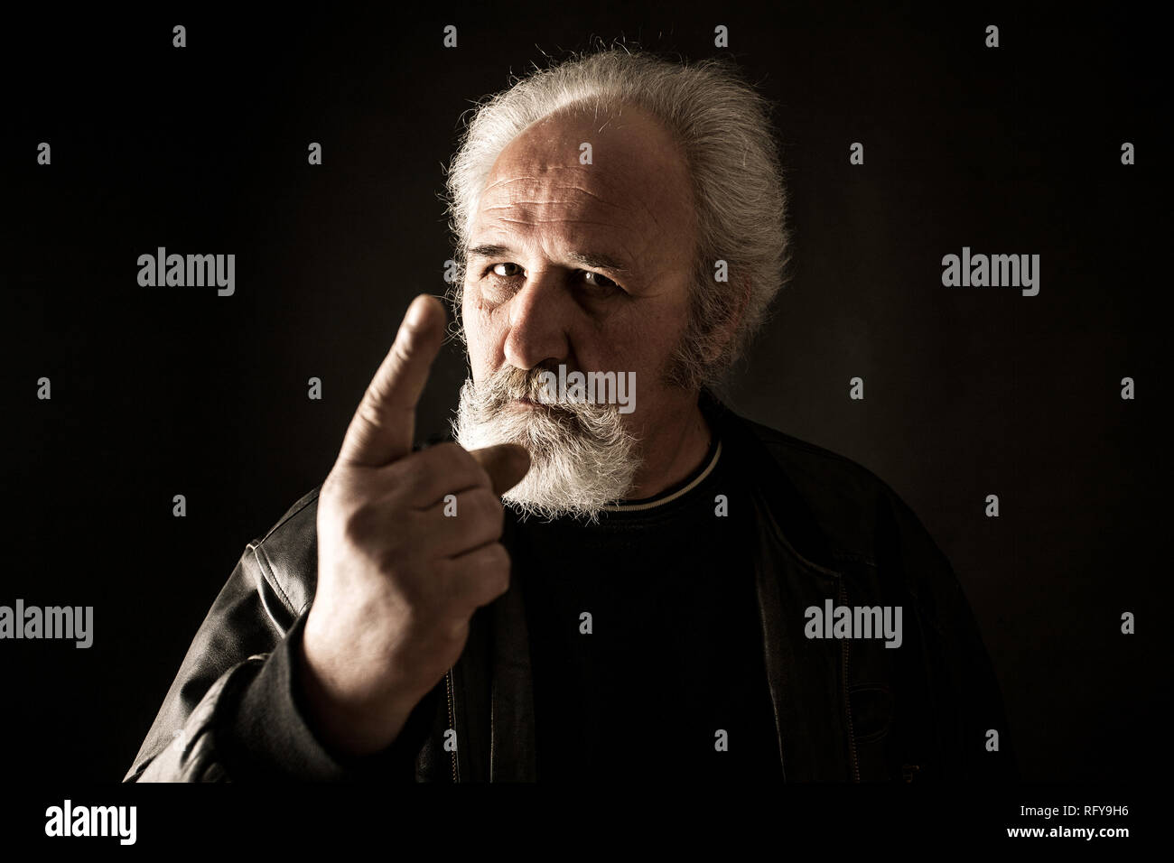 Grumpy man against black background Stock Photo