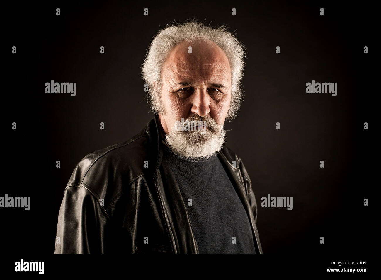 Grumpy man against black background Stock Photo